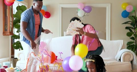 Family Tidying After Birthday Celebration with Balloon Decor
