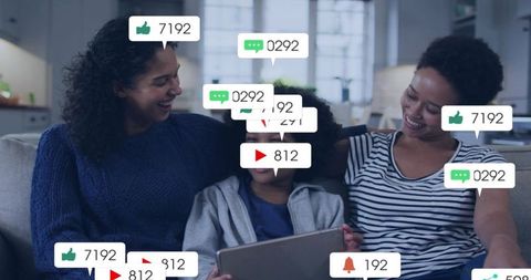 Smiling family sharing tablet with social media notifications and streaming reactions