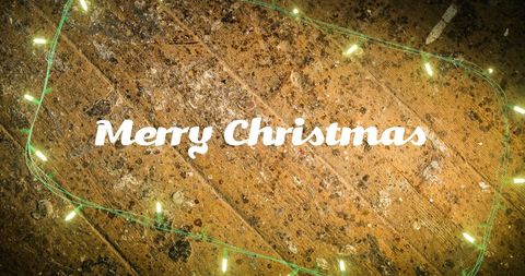 Festive "Merry Christmas" Text on Rustic Wood with Fairy Lights