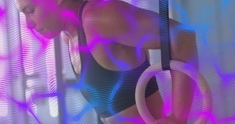Female athlete gripping gym rings training upper body strength purple blue overlay