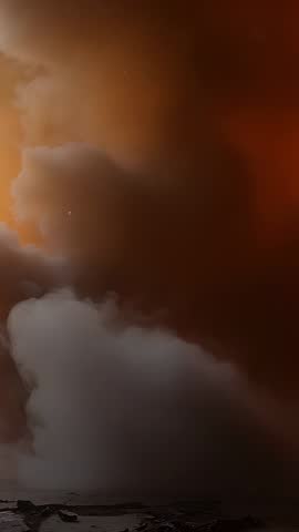 Sun sinking sending cumulus bank drifting over shore, orange glow fading into brown, vertical video