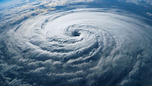 Spinning hurricane eye over ocean from orbital view revealing dense spiral cloud bands