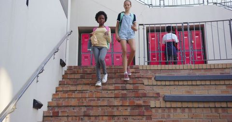 Diverse Girls Descending School Staircase with Backpacks Outdoors