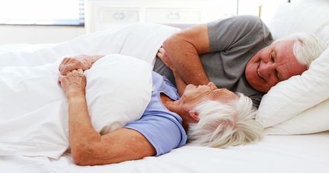 Senior Couple Relaxing Comfortably in Cozy Bedroom Setting