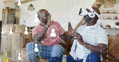 Father and son playing with virtual reality headset on couch, home technology interaction