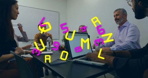 Business team collaborating around conference table with laptop front and neon letters overlay
