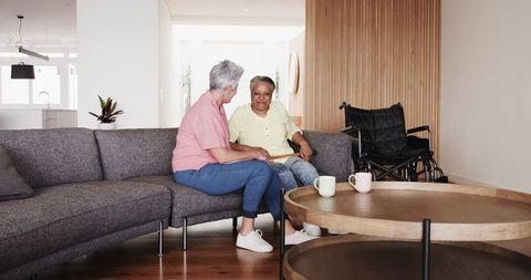 Senior Lesbian Couple at Home Walking with Cane and Wheelchair Assistance