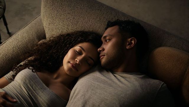 Young couple resting on sofa in soft warm evening light