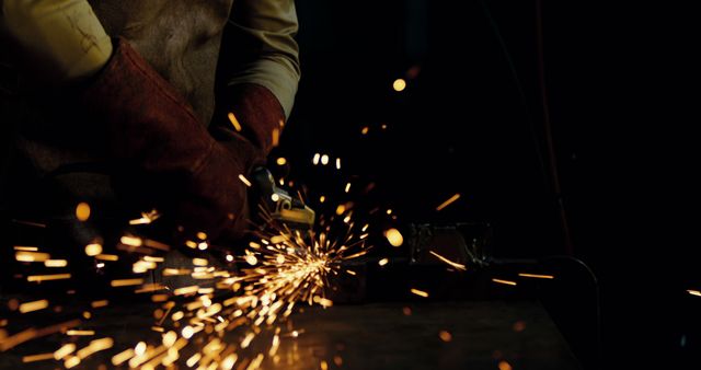 Man Working With Angle Grinder Producing Sparks in Dark Workshop - Download Free Stock Images Pikwizard.com