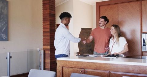 Real estate agent meeting happy couple in modern kitchen