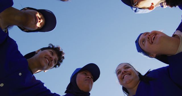 Happy Team Huddling Together in Uniforms Under Clear Blue Sky - Download Free Stock Images Pikwizard.com