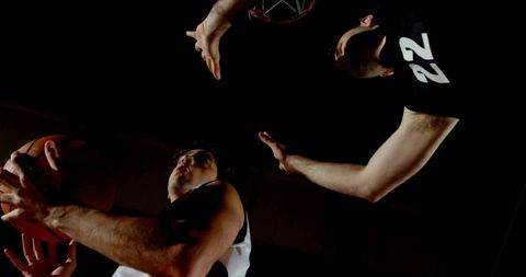 Intense basketball duel under hoop in action