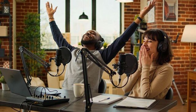Joyful Cohosts Recording Podcast in Cozy Brick Home Studio Celebrating Success