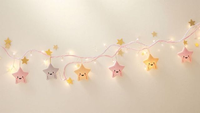Pastel star led garland glowing on nursery wall with warm fairy lights and gold stars