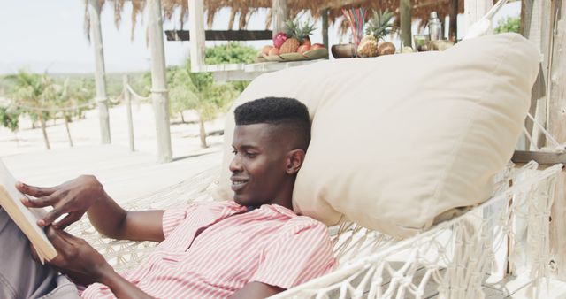 Young Man Relaxing on Hammock Reading Book at Tropical Beach Resort - Download Free Stock Images Pikwizard.com