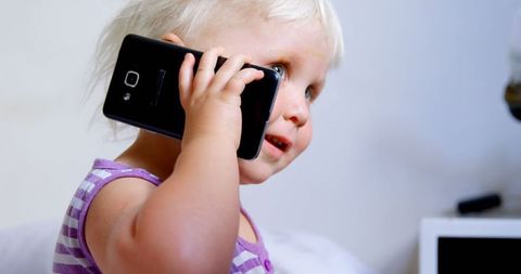 Cute Child Talking on Smartphone Indoors