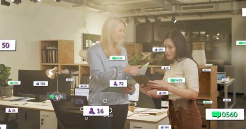 Discussing coworkers reviewing tablet and papers in modern office with social overlays