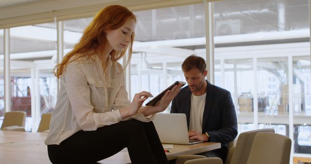 Young Businesswoman Using Tablet and Businessman Working on Laptop in Modern Office - Download Free Stock Images Pikwizard.com