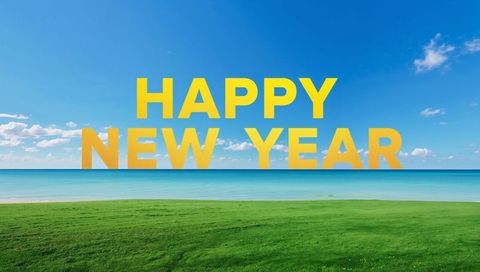 Golden happy new year text over turquoise ocean and lush green lawn holiday greeting