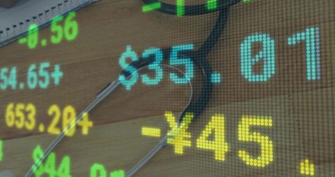Stethoscope on wooden desk with digital currency overlay depicting healthcare finance data
