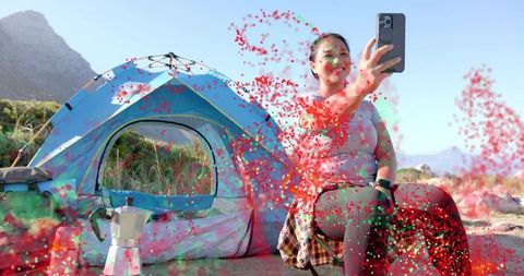 Excited camper taking selfie at scenic mountain campsite