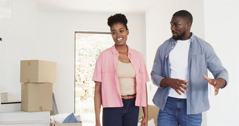 Happy couple embracing house move with cardboard boxes