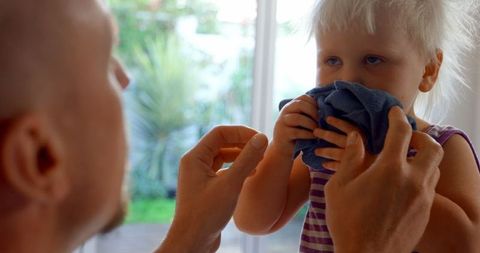 Father Caring for Young Daughter at Home Using Napkin