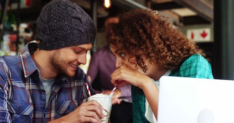 Young Couple Sharing Milkshake in Cozy Cafe Ambience