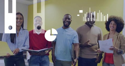 Diverse team smiling and holding folders while displaying data charts and graphs in office