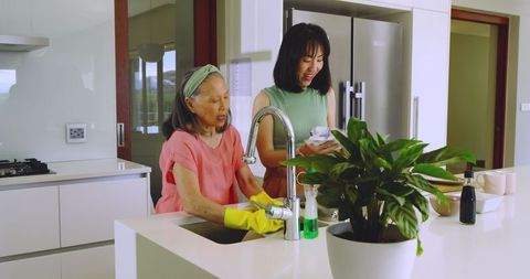 Asian Family Washing Dishes in Modern Kitchen
