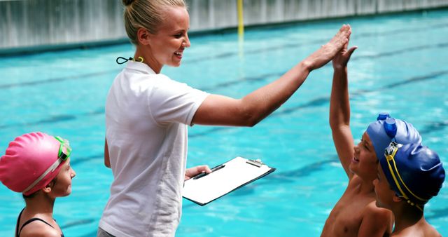 Swimming Instructor Celebrating with Young Swimmers by Pool - Download Free Stock Images Pikwizard.com