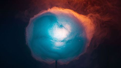 Glowing blue cotton candy halo emitting neon vapor on stick for moody dessert concept
