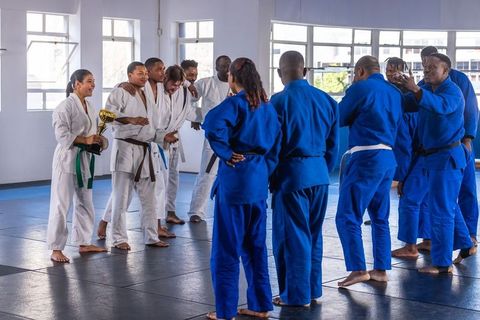 Diverse martial arts teams celebrating victory with trophy