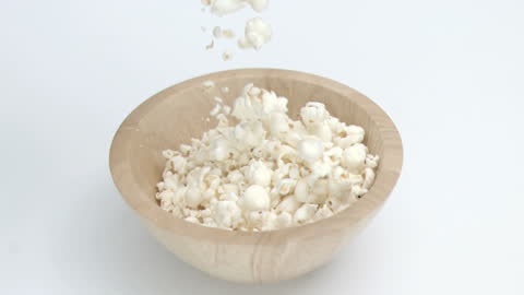 Popcorn Falling Into Wooden Bowl in Slow Motion