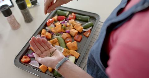 Woman Seasoning Fresh Mixed Vegetables in Kitchen, Healthy Cooking Concept