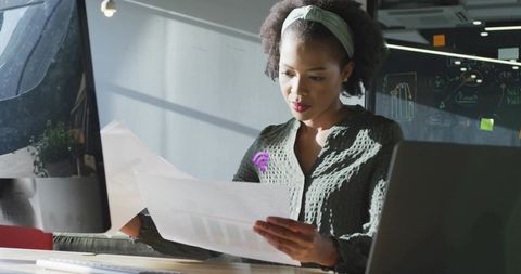 Focused Professional Analyzing Printed Charts in Modern Workspace