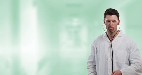 Doctor Wearing Lab Coat Holding Stethoscope in Blurred Hospital - Download Free Stock Images Pikwizard.com