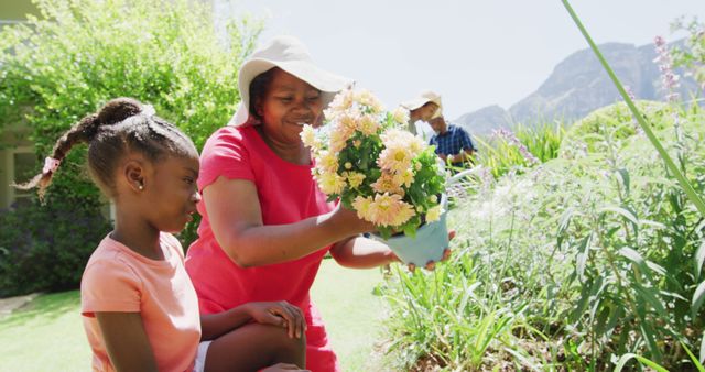 Happy Grandmother and Granddaughter Planting Flowers in Sunny Garden - Download Free Stock Images Pikwizard.com