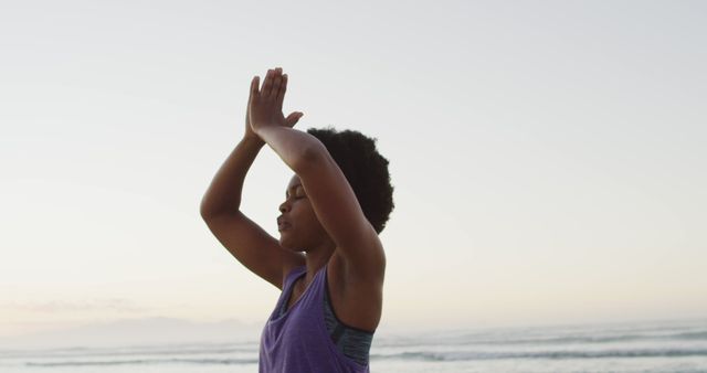 African american woman practicing yoga and meditating on sunny beach - Download Free Stock Photos Pikwizard.com