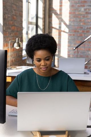 Confident African American Woman Focused on Laptop in Office Setting