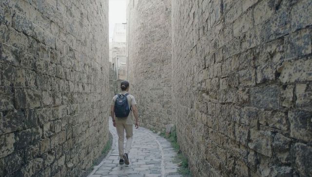 Walking Through Narrow Historic Stone Alley with Backpack, Urban Traveler Exploring