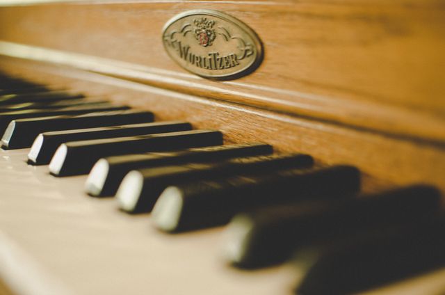 Detailed view of Wurlitzer piano keys with a wooden finish. This perfect shot highlights the craftsmanship and classic design of the piano. Ideal for music-related content, vintage and retro themes, and promotional materials for musical lessons or events.