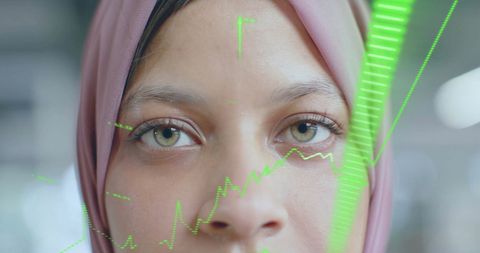 Businesswoman in Hijab Analyzing Financial Data Overlay