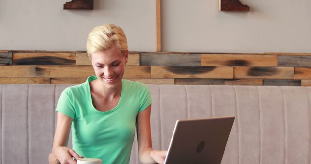 Smiling Woman Enjoying Coffee and Working on Laptop in Cafe - Download Free Stock Images Pikwizard.com