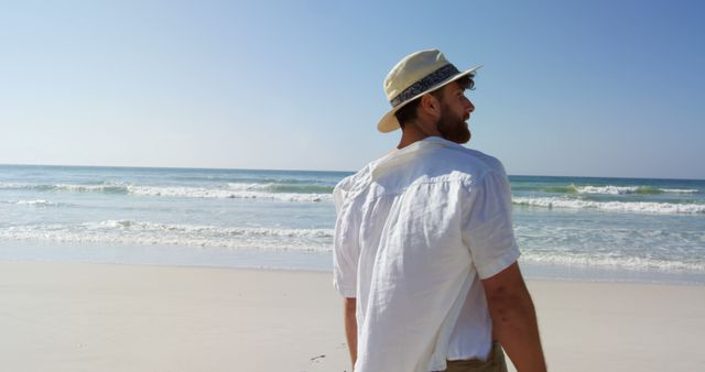 Man Enjoying Serene Beach Walk on Sunny Day - Download Free Stock Images Pikwizard.com