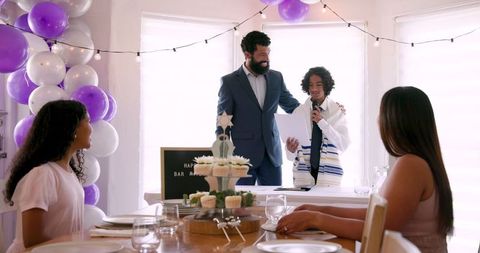 Family celebrating bar mitzvah with speech and decorations