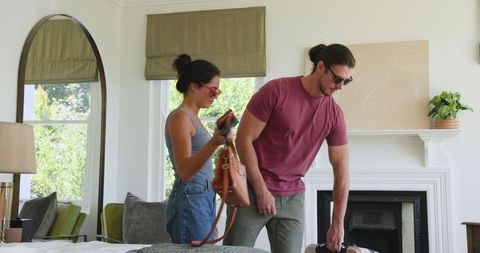 Couple Packing for Vacation Together in Bedroom