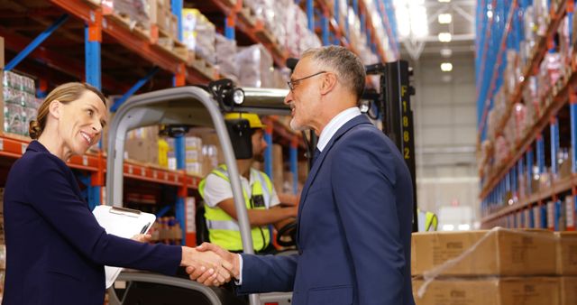 Business Agreement in Warehousing Facility with Boxes and Forklift in Background - Download Free Stock Images Pikwizard.com