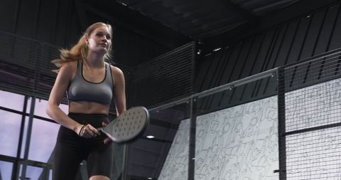 Female athlete playing paddle sport in indoor arena