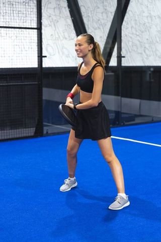 Female Athlete Holding Racket on Blue Padel Court in Action